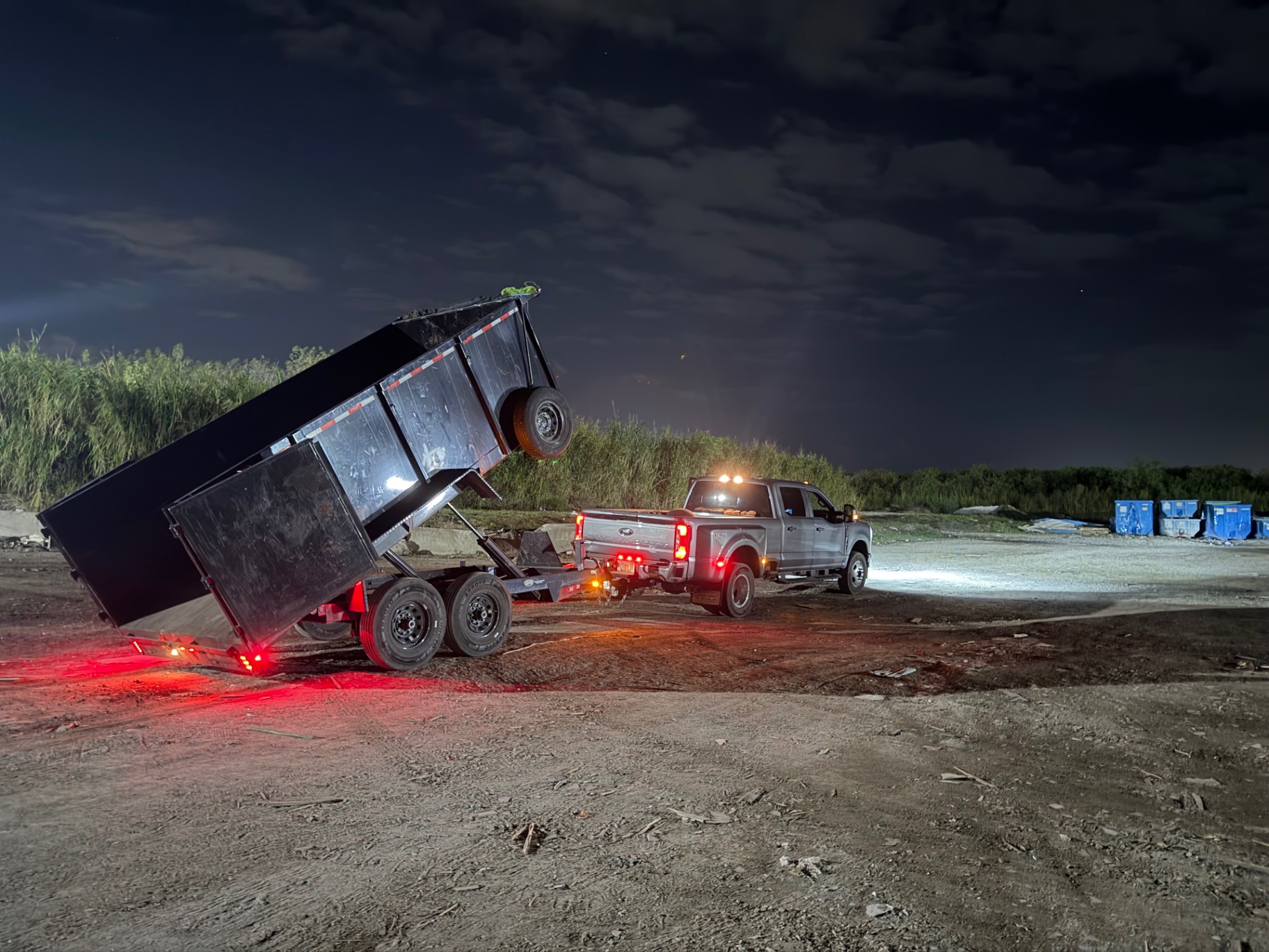 Dump trailer unloading construction debris at night